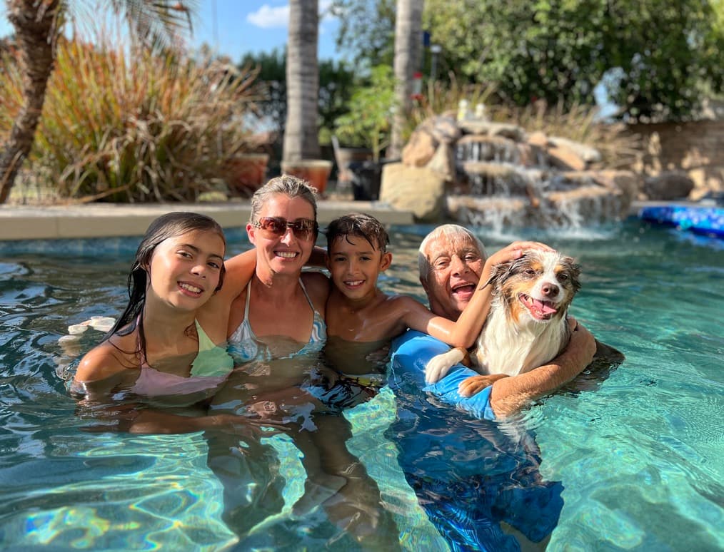 Michael and family in pool with dog